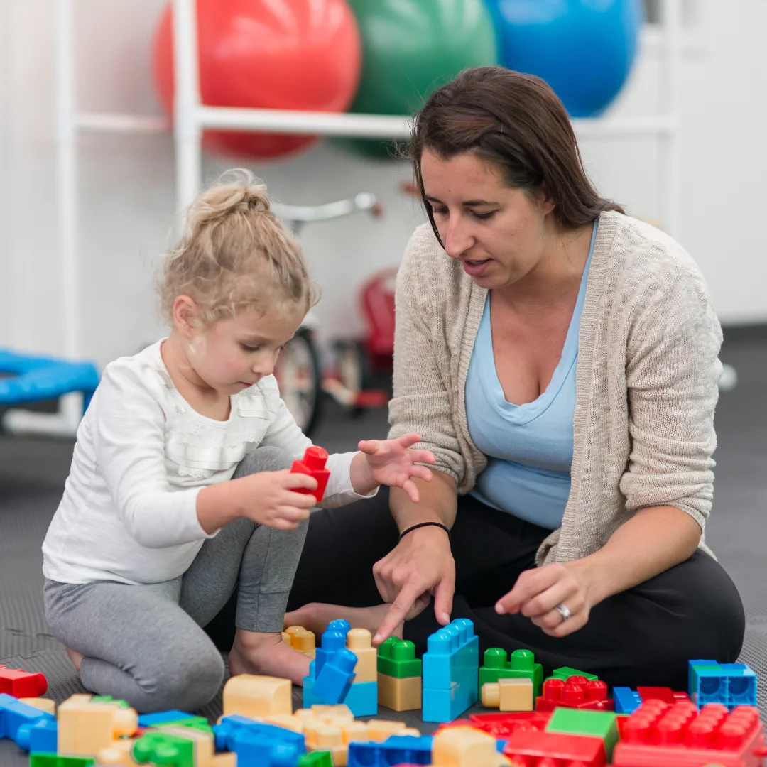 Therapist and child building with blocks during a play-based session